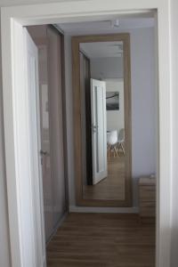 博格泽利卡Apartament z ogrodkiem的走廊上设有镜子,房间设有桌子