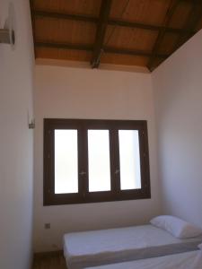 塞埃欣Albergue Coto Real de la Marina的客房设有2扇窗户和1张床