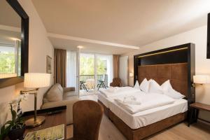 西兰德罗Genusshotel Goldene Rose的酒店客房设有一张大床和一张书桌。