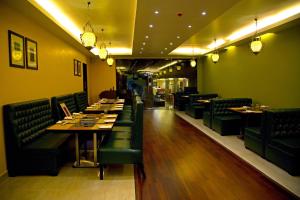钦奈休闲住宿 - 高级套房的餐厅拥有绿色的墙壁和桌子以及绿色的椅子