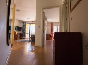 丰沙尔Apartamentos Turisticos Avenue Park的客厅铺有硬木地板,客厅配有桌子
