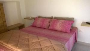 马戈马达斯B&B Stella Maris的一间卧室配有一张带粉色床单和枕头的床。
