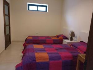 梅利哈Mandalay的一间卧室设有两张床和窗户。