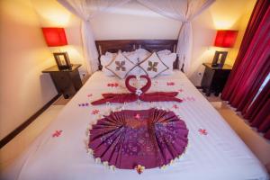 佩母德兰曼斯小屋及Spa酒店的一间卧室配有一张带遮阳伞的床