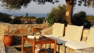 阿莫利亚尼岛Liani Ammos的一张白色沙发,坐在石墙旁边