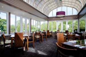 索尔兹伯里传统玫瑰与王冠酒店的用餐室设有桌椅和窗户。