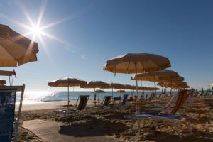 皮内托米拉马雷酒店的海滩上的一组椅子和遮阳伞