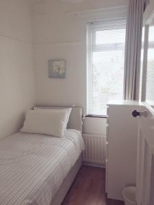贝尔法斯特Belfast Holiday Home的一间小卧室,配有床和窗户