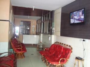 福塔莱萨Pousada Vianna's的客厅配有椅子和墙上的电视