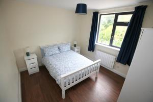 BurtonportHarbour front apartments的卧室配有白色婴儿床和窗户。