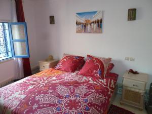 沃利迪耶Dar Chebba的卧室配有一张床,墙上挂着一幅画