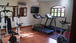 莱昂Hotel Cacique Adiact的健身房设有数辆健身自行车和电视