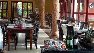 Kwabenyan阿克拉皇家城堡公寓及套房的用餐室配有桌椅和葡萄酒瓶
