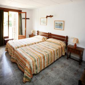 卡拉菲格拉洛伦佐别墅酒店的一间卧室配有一张带条纹毯子的大床