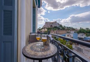 雅典帕拉第奥之家旅馆的阳台上的桌子和两杯葡萄酒