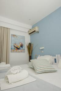 波罗斯Nissos Poros的一间卧室设有两张床,墙上挂着一幅画