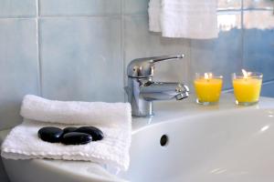 卡斯蒂里昂纳·德拉佩Residence Teclini的浴室水槽设有2个蜡烛和1条毛巾