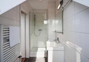 埃森伯纳诺特住宿加早餐旅馆的带淋浴和盥洗盆的白色浴室