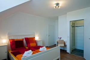 埃森伯纳诺特住宿加早餐旅馆的一间卧室配有红色和橙色枕头的床