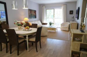 拉塔Apartament Rezydencja Bryza Jurata的一间带桌椅的客厅和一间客厅。