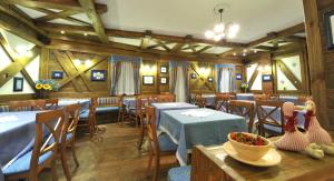 帕苏德尔托纳莱阿达梅洛酒店的用餐室设有桌椅和木墙