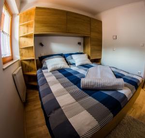 卢斯Apartments BBI的一间卧室配有一张大床和木制床头板