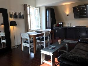 波尔多Appart Hypercentre - Le Saint Projet的厨房以及带桌椅的起居室。
