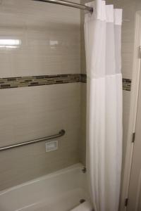 旧金山旧金山海湾大桥酒店的一间带白色淋浴帘的浴室