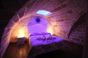 滨海波利尼亚诺Dimora Nonna Catarì的紫色客房,砖墙内有一张床