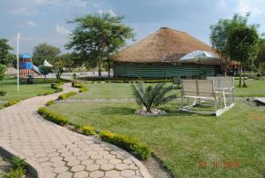 Kitwe莫巴酒店及会议中心的公园里带长凳的草屋