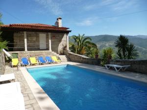 吉尔斯Casas das Guimbras的一个带椅子的游泳池以及一座房子