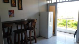 比亚维森西奥Casa Campestre La Heredera的厨房设有带凳子和冰箱的酒吧。