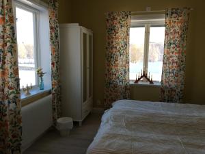 奥萨Orsa Station Bed and Breakfast的一间卧室设有一张床和两个窗户。