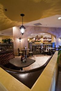 拉斯维加斯Tuscany Suites & Casino的一间带桌椅的餐厅和一间酒吧