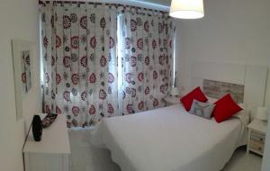 厄尔梅达诺Montaña Roja的卧室配有白色的床、红色枕头和窗户