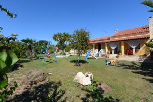 阿尔米罗斯海滩Villa Anna的一个带游乐场和房子的庭院