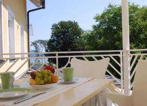 赖弗尼茨伯肯海公寓式酒店的阳台上的桌子上放着一碗水果