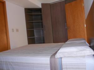 累西腓Flat Beira Mar的一间卧室配有一张床和木制衣柜