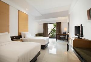 玛琅桑提卡玛琅酒店的酒店客房设有两张床和一台平面电视。