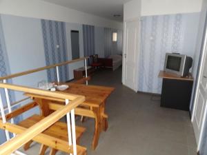 陶格夫匹尔斯瑞博酒店的客厅配有木桌和电视。