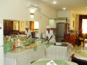 马普托Hotel Royal Residencial的两名厨师站在厨房准备食物