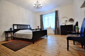 索波特Victus Apartamenty, Apartament Oslo的一间卧室配有一张床、一把椅子和一个吊灯。