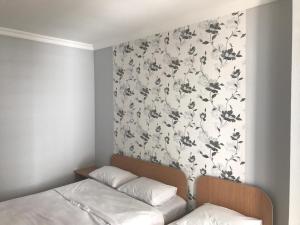 卡瓦拉提Kvariati - Guest House的一间卧室设有一面墙,墙上装饰着花卉图案的壁纸