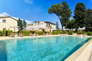 蒙泰斯佩尔托利拉卡尔万别墅酒店的一个带椅子的游泳池和一个背景房子