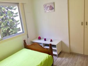 利马索尔Sea View Apartment的一间卧室配有一张床、一张书桌和一个窗户。