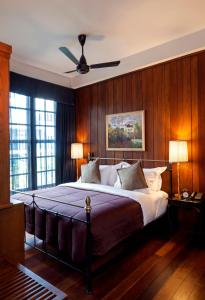 曼谷曼谷出版社酒店的一间卧室配有一张大床和吊扇