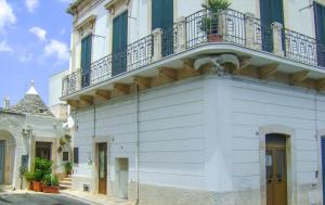 阿尔贝罗贝洛拉奎拉住宿加早餐旅馆的一座白色的建筑,上面设有一个阳台