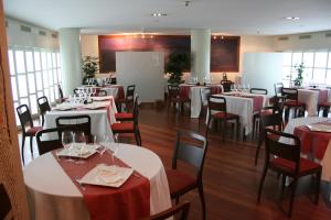 贝坦索斯贝坦索斯别墅酒店的用餐室配有白色的桌子和红色的椅子
