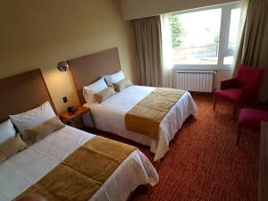 乌斯怀亚拉斯雷格丝酒店的酒店客房,配有两张床和椅子