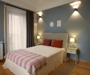 萨布盖鲁Abrigo da Montanha - Alojamento Familiar的一间卧室配有一张带两个红色枕头的床